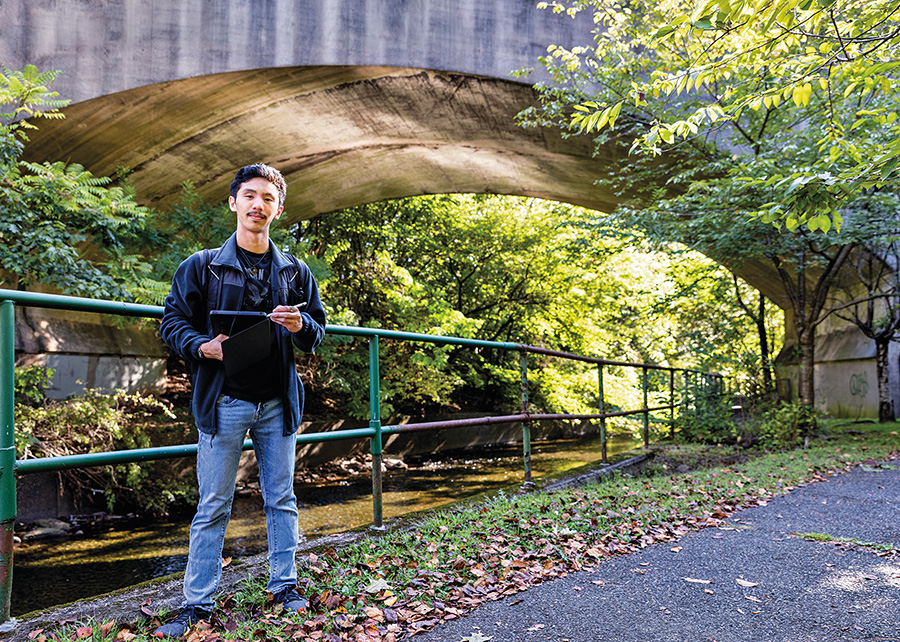 A man stands near a river