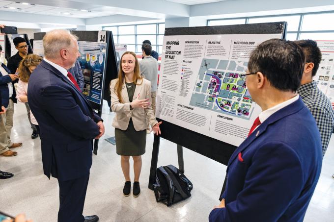 Undergraduates Erin Foody and Aaron Dimaya (not pictured) share their project “Mapping the Evolution of NJIT” with President Lim and Provost Pelesko during the Dana Knox Student Research Showcase.